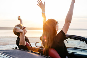 young happy couple in cabriolet in sunset light