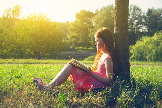 Little Redhead Girl Reading Book At Nature