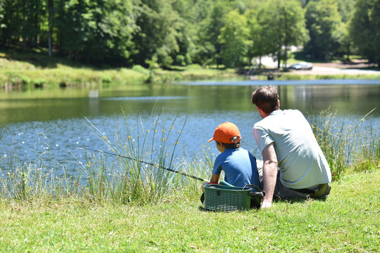 Dad With Little Boy Fishing By Mountain Lake