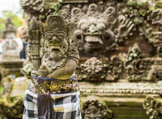 Traditional demon guards statue carved in stone on Bali.