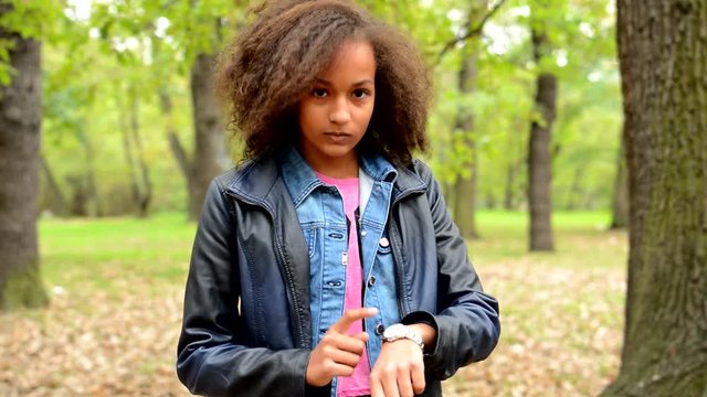 young african punctual impatient girl warn - is time already - target watches with finger - eye contact