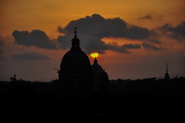 Puesta de sol en la cúpula del  Vaticano en Roma