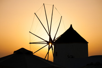 Beautiful sunset through a windmill on Santorini island, Greece.