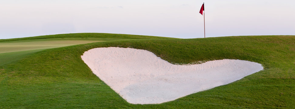 Heart shaped sand bunker in front of golf green