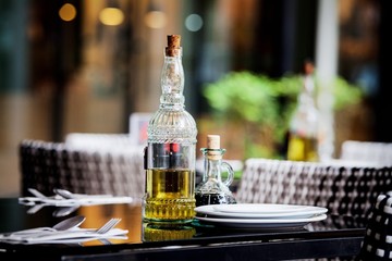 Olive oil, salt and pepper on a table for dining