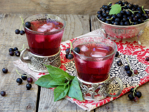 Fresh currant juice or compote with black currant on table