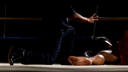 Fototapeta na wymiar Referee countdown boxer fighter lying on ground