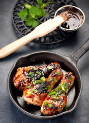 Roasted chicken legs teriyaki sauce in a frying pan