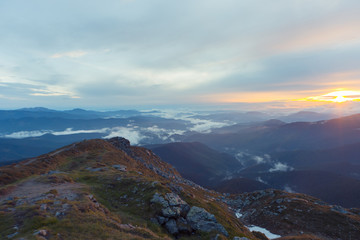 Fototapeta na wymiar A beautiful sunrise in the clouds in the high mountains.