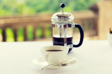 cup of coffee and french press on table 