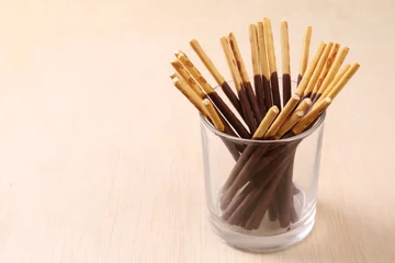 Fototapeten Chocolate dipped biscuits sticks in glass holder © t4nkyong