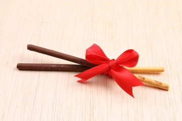 Pair of chocolate dipped biscuit sticks tied to ribbon