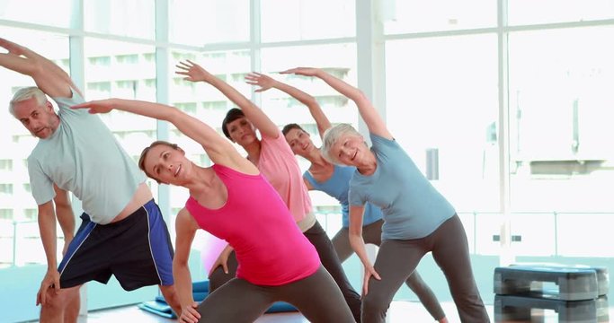 Aerobics class stretching their arms together