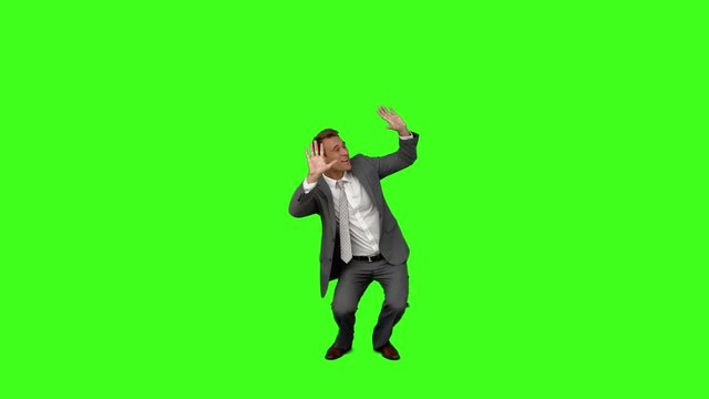 Businessman standing and cowering on green screen background
