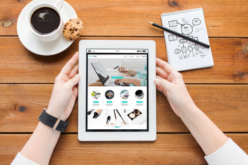 close up of woman with tablet pc on wooden table