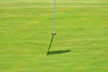 Obraz premium Nice golf course on a sunny summer day. Hole with a flag. Popular outdoor sport.
