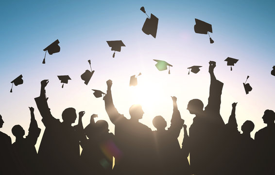 silhouettes of students throwing mortarboards