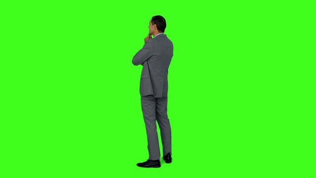 Businessman standing and thinking on green screen background