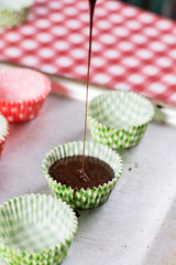 Making chocolate cream muffins. Pouring chocolate cream in paper