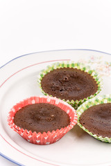 Three homemade chocolate muffins on the plate isolated over whit