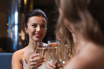 happy women with champagne glasses at night club