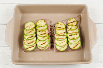 Cooking oven-roasted fish fillet with courgettes and tomatoes un