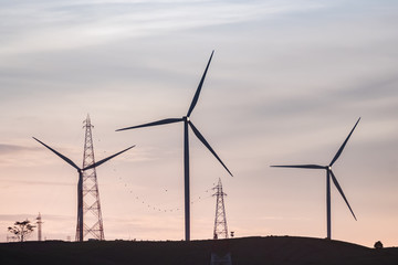 Wind turbine generator silhouette with twilight sky background. 