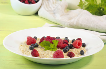 Oatmeal in plate on wooden background