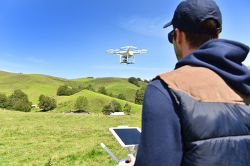 Man handling drone in nature - obrazy, fototapety, plakaty
