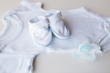 Obraz na płótnie Canvas close up of baby boys clothes for newborn on table