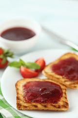 French toasts with jam and strawberry on wooden table