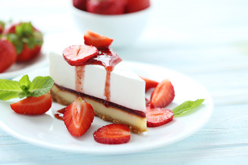 Strawberry cheesecake on plate on blue wooden table