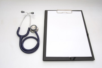 Stethoscope and blank clipboard with a sheet of white paper.