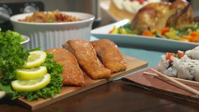 Chicken Tilt Down to Salmon. camera moves from chicken and racks focus to salmon on a table for a party. Surrounded by other foods
