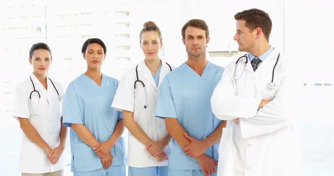 Frowning medical team with hands together