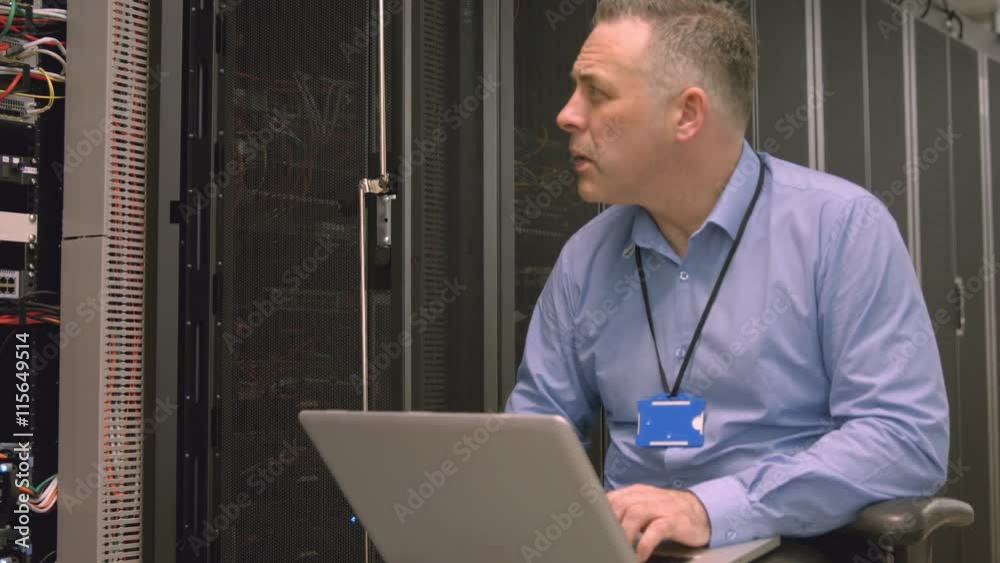Poster technician using laptop to analyse server