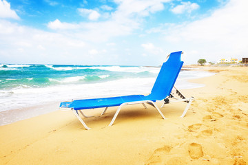 blue chair on Malia beach, Crete Greece, toned
