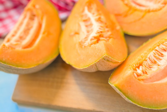 Cantaloupe melon slices on rustic wooden table