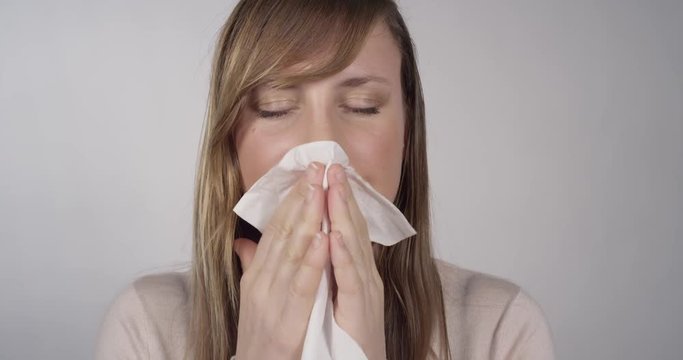 CLOSE UP: Female blowing her nose