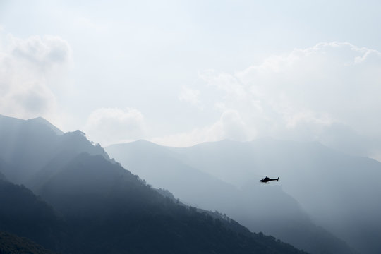 Helicopter flying in the misty mountains