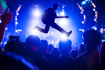 Singer singing on concert stage with ray of illuminated, Singer and guitar on stage