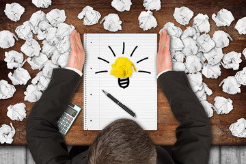 businessman clearing desktop with notepad and lightbulb idea symbol from paper snarl  / ...