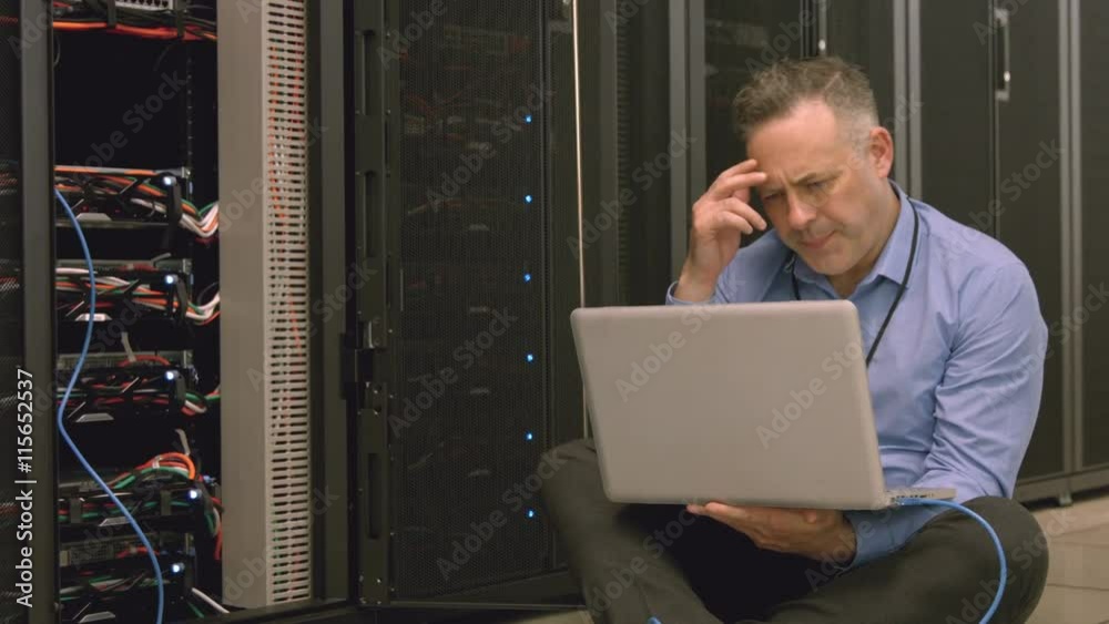 Poster technician using laptop to analyse server