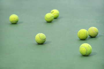 old tennis balls for practicing in green tennis court