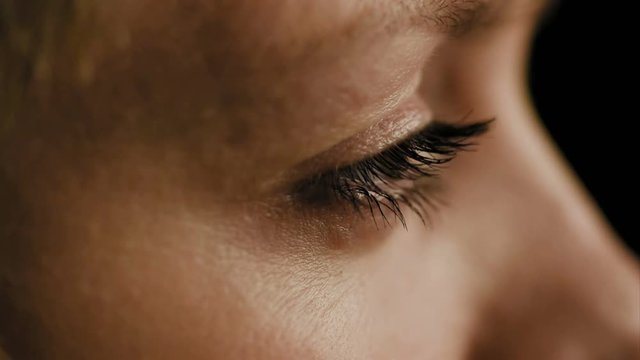 Female woman's eyes closeup side view slow motion. 4K UHD video footage.