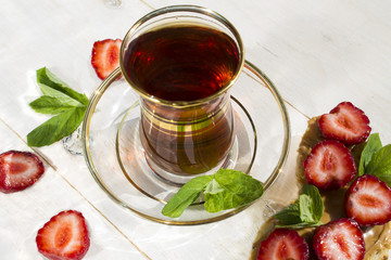 Cup of black tea and toast with peanut butter and strawberries
