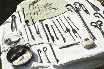 Medieval medical instruments on a table.