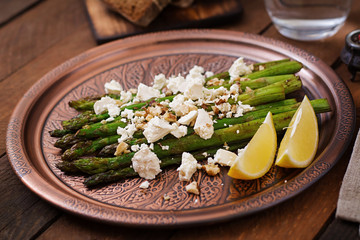 Warm salad of roasted asparagus, feta cheese, nuts, flavored with lemon juice