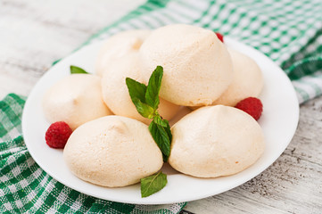 Meringues with raspberry and mint leaves