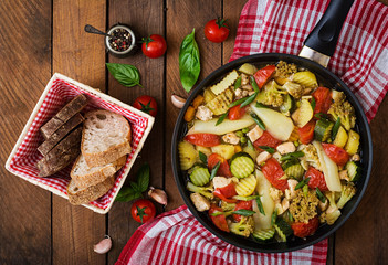 Dietary menu. Steamed vegetables with chicken fillet in pan on the wooden background. Top view